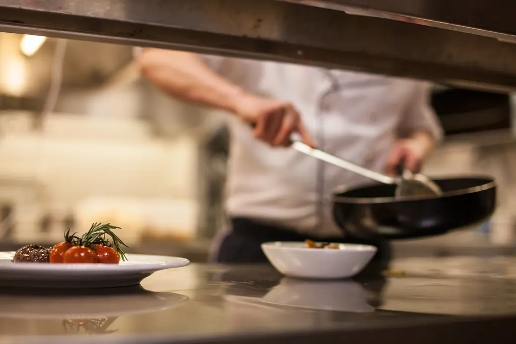 Cozinheiro ao fogão na cozinha de um restaurante